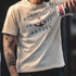 Person wearing a t-shirt with 'Midway Islands 1942 Battle' design, holding a can.